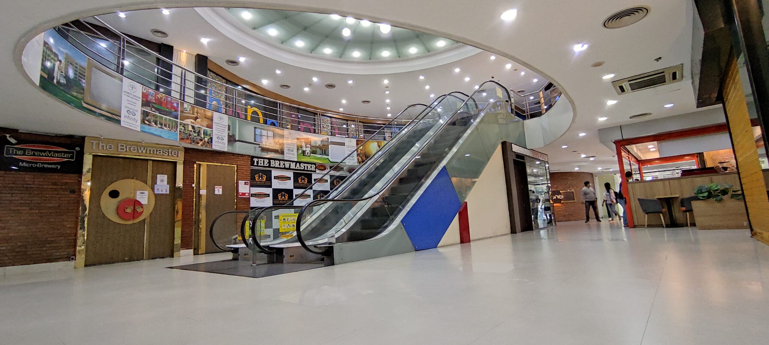 This image shows a brightly lit retail shop, likely a cafe or restaurant, occupying a ground-floor space within an Infinity Group Retail project in Salt Lake Sector V, Kolkata. The large glass frontage is a key feature, offering high brand potential by providing visibility to passersby. This retail space exemplifies a sound location strategy for a business that relies on catering to the daily needs of the office-going crowd